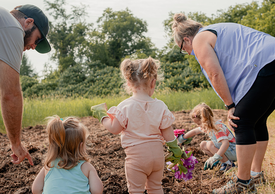 Young children and educators engaged in outdoor nature play at Barn Yard Buddies farm